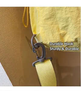 Detail of durable grey plastic hook and yellow woven strap on a nylon bucket backpack