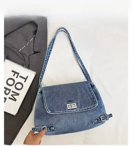 Détail du sac à épaule en denim délavé avec fermoir rotatif argenté et boucles de style rétro