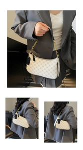 Detail view of crescent shoulder bag featuring chain print and gold metal strap link