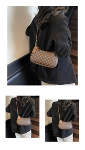 Detailed view of brown monogram crescent bag with gold hardware and leather strap