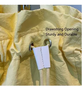 Detail of drawstring closure with metal eyelet and durable nylon fabric on yellow backpack