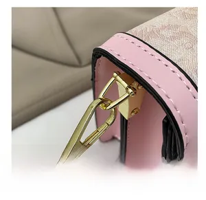 Detail of premium golden metal hook and fine stitching on a pink floral shoulder bag