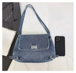 Détail du sac cabas en jean vintage montrant le fermoir en métal et le tissu bleu délavé