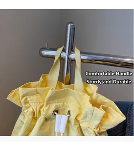 Detail of yellow drawstring bucket bag showing durable nylon fabric and reinforced handles