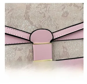Detailed close-up of vintage floral embroidery and pink leather on a woman handbag