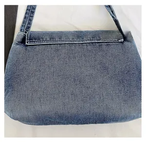 Gros plan sur la texture du tissu denim bleu clair et l'effet délavé du sac fourre-tout