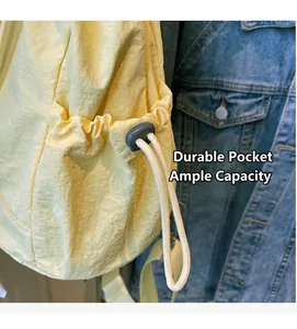 Close-up of a yellow nylon backpack side pocket with drawstring and grey buckle detail