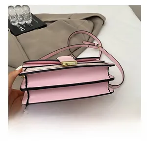 Detailed side view of pink faux leather bag with layered gusset and black edge finish
