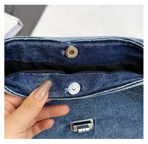 Détail d'un sac cabas en denim avec fermeture magnétique et serrure décorative
