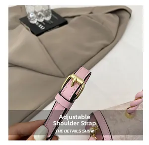 Detail of pink pebbled leather shoulder bag showing adjustable strap with gold metal buckle