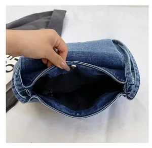 Vue intérieure du sac en jean avec doublure noire, boucle magnétique et poche zippée