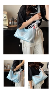 Detalle de bolso hobo azul claro grande con encaje blanco y colgantes de corazón