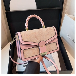 Detail of pink embroidered handbag with woven handle in a luxury gift box setting