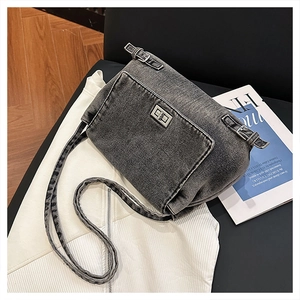 Détail du sac à bandoulière en denim gris foncé avec fermeture à fermoir tournant