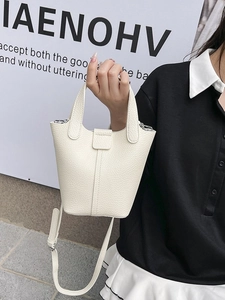 Chic beige lychee leather mini bucket bag with top handles and slender shoulder strap