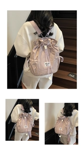 Detail of light purple drawstring backpack showing pleated nylon texture and shoulder straps