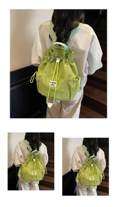 Detail of avocado green drawstring bucket backpack showing nylon texture and label