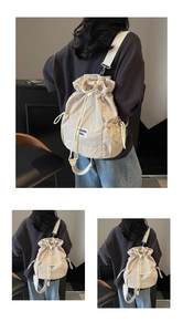 Detail of off-white canvas drawstring backpack with adjustable straps and textile label