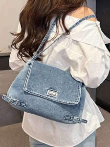 Sac fourre-tout en denim bleu délavé avec fermoir rotatif argenté et boucles chic