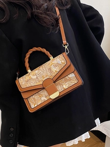 Elegant tan shoulder bag with botanical embroidery and woven handle in professional style