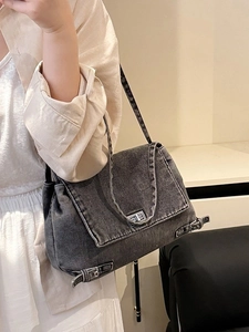 Sac fourre-tout en denim gris avec fermoir rotatif argenté porté par un mannequin