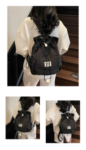 Detail of black drawstring backpack showing the nylon texture and brand patch on model