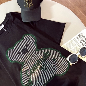 Detail of oversized cotton t-shirt with rhinestone bear design and streetwear accessories