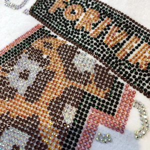 Détail de la broderie en strass de qualité sur le tissu d'un t-shirt en coton blanc épais