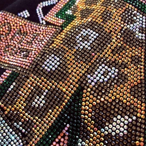 Vue détaillée de strass colorés sur le tissu en coton noir de qualité d'un t-shirt