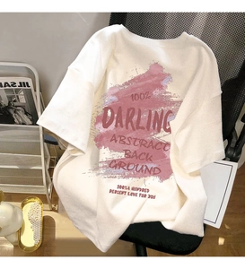 Close-up of white cotton T-shirt featuring pink abstract print and red DARLING lettering