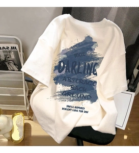 Detail of white cotton T-shirt featuring blue abstract print and artistic lettering design