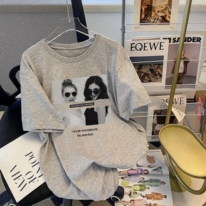 Detail of grey cotton T-shirt featuring portrait art print draped over a modern chair