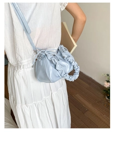 Détail du sac à main plissé bleu clair avec poignée froncée et bandoulière réglable