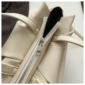 Detailed macro view of silver zipper on premium lychee grain leather shoulder bag