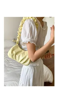 Gros plan du sac nuage plissé jaune crème avec bandoulière à volants et texture douce