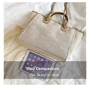 Grand sac cabas tissé beige avec bandoulière chaîne à côté d'un iPad pour la taille
