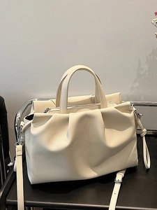 Cream white ruched tote bag with litchi texture on a chair in a minimalist setting