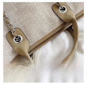 Gros plan du sac cabas beige tressé avec poignée en cuir marron et chaîne en métal argenté