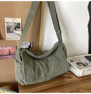 Detail view of the olive green canvas messenger bag with large flap and side pocket