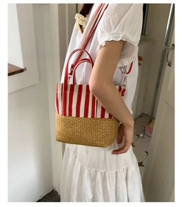 Detail of red striped canvas and straw woven handbag featuring stylish material contrast