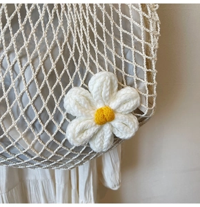 Close-up of cotton mesh bag with a large crochet flower and satin lining detail