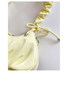 Détail de la bandoulière plissée jaune avec ferrures argentées et nœud papillon