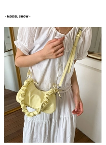Gros plan détaillé du sac nuage plissé jaune pâle avec une finition en cuir verni