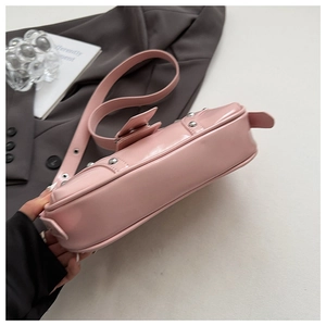 Détail du sac en cuir verni rose cerise avec clous argentés et bandoulière