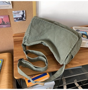 Close-up of olive green canvas messenger bag showing texture and durable strap details