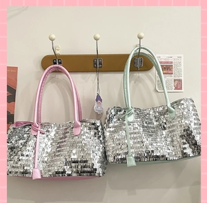 Detailed view of silver sequin tote bags with pink and green leather straps on hooks