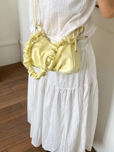 Sac à épaule plissé jaune pâle avec poignée nuage porté par un mannequin sur fond blanc