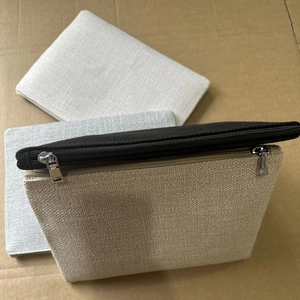 Détails de trois pochettes en toile de lin avec fermetures éclair sur fond de carton