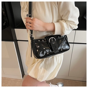 Détail du sac sous le bras en cuir noir brillant avec rivets argentés et boucles en métal