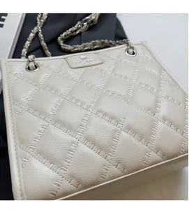 Vue détaillée du sac cabas crème avec texture matelassée et chaîne argentée